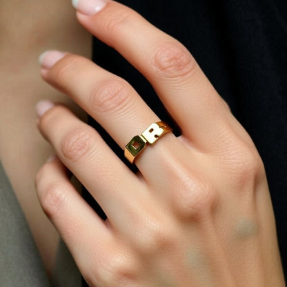 gold initial ring on a hand