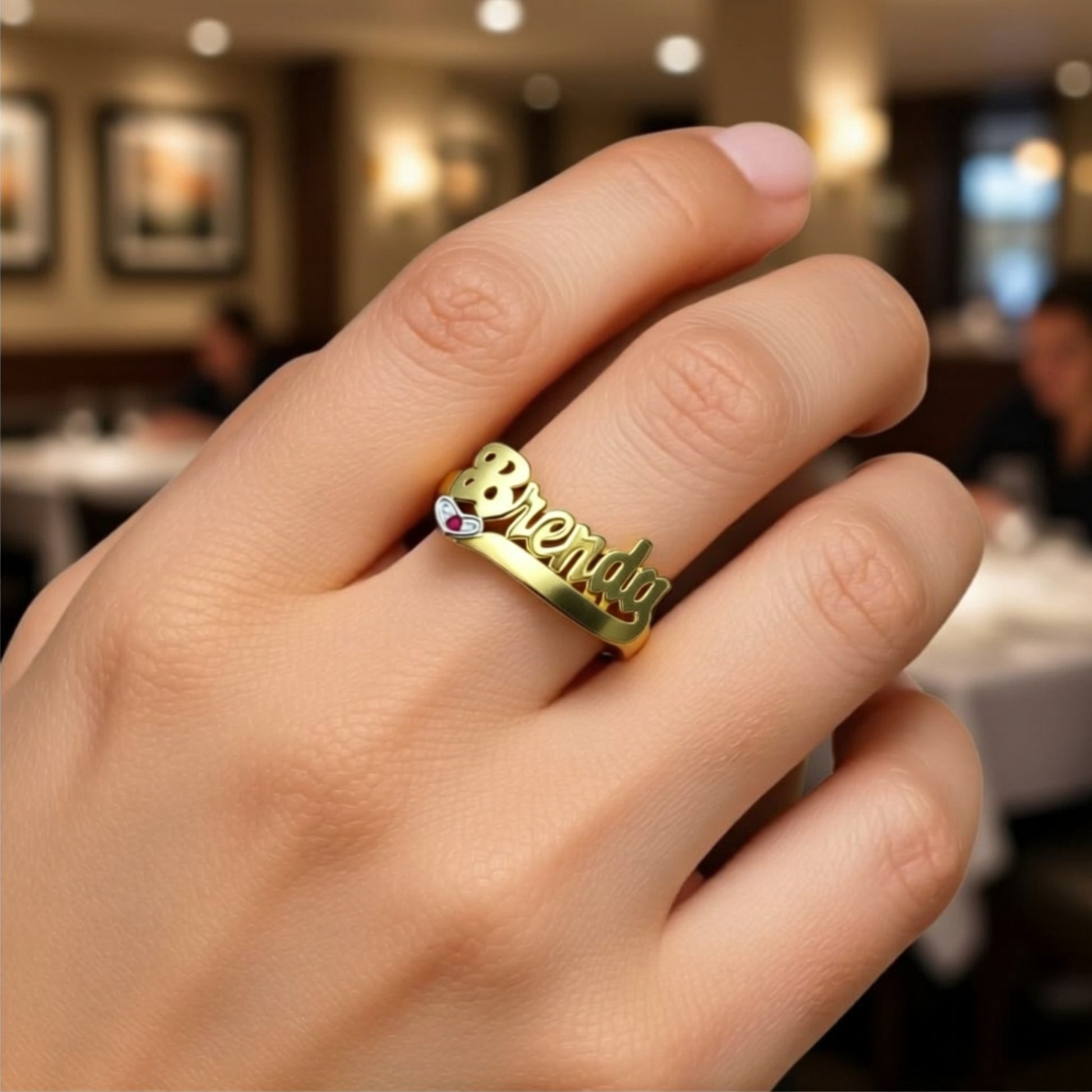 name ring with birthstone on a hand