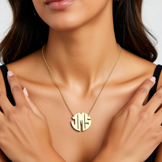 Gold necklace with a round pendant on a model against a neutral background