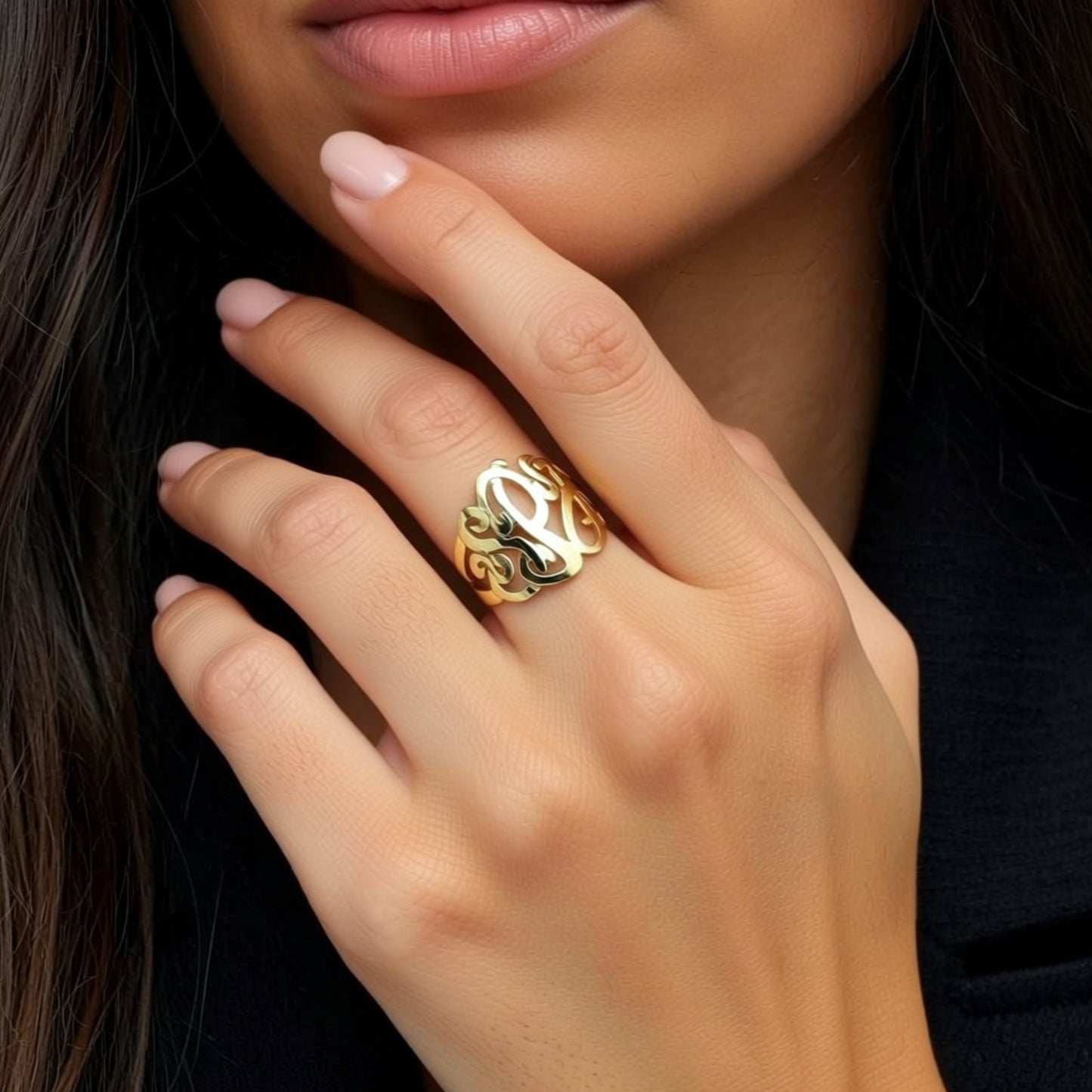 gold monogram ring on a hand
