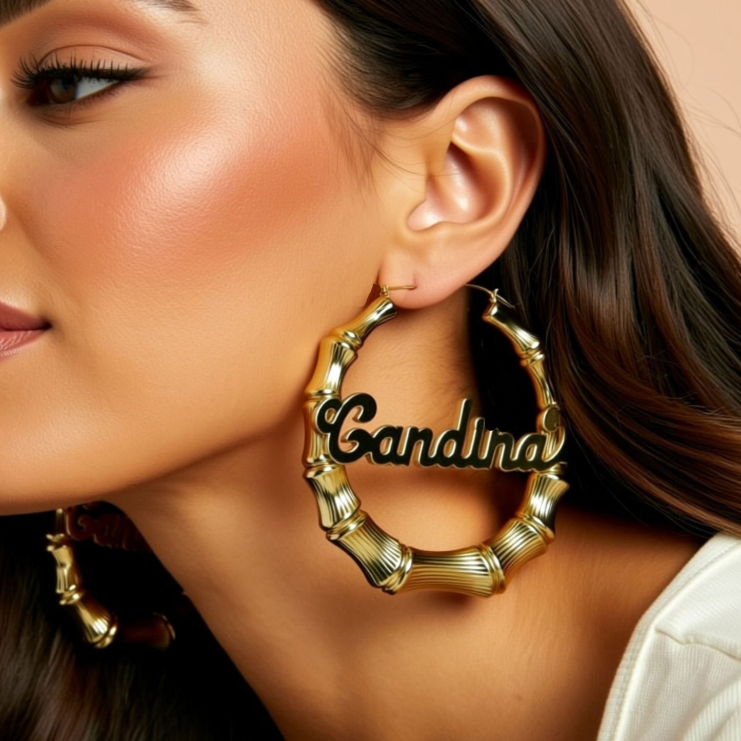 gold name hoop earrings on a person