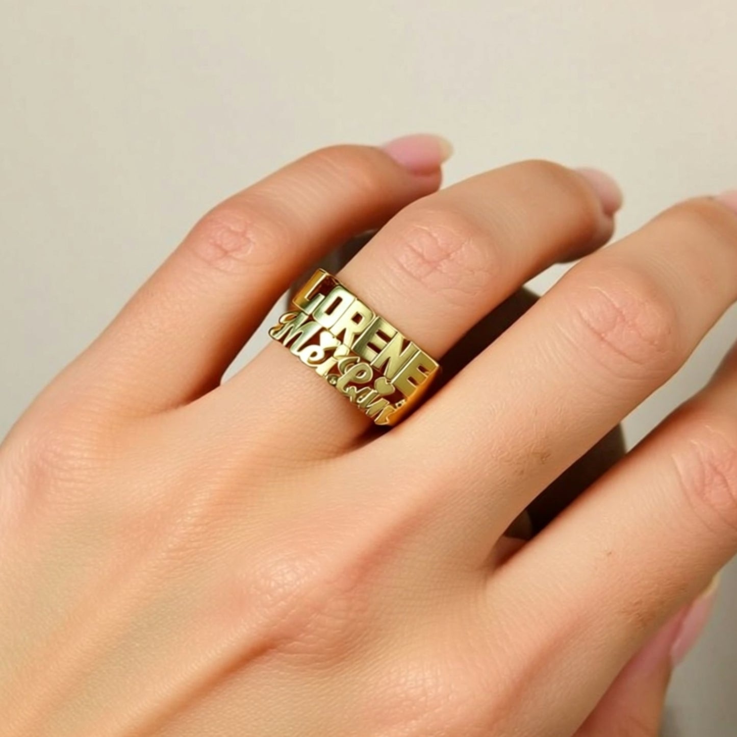 two name gold ring on a hand